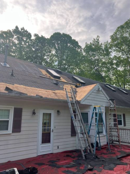 Roof tear-off in progress with ladders in position