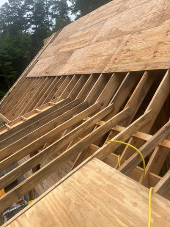 Fresh plywood roof decking installed over new rafters