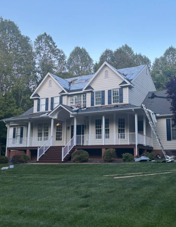 Two-story home mid-project with a section of new roof underlayment installed